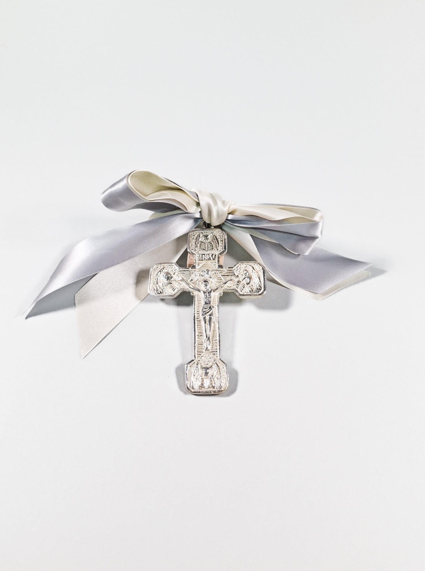 Cruz plateada con moño gris