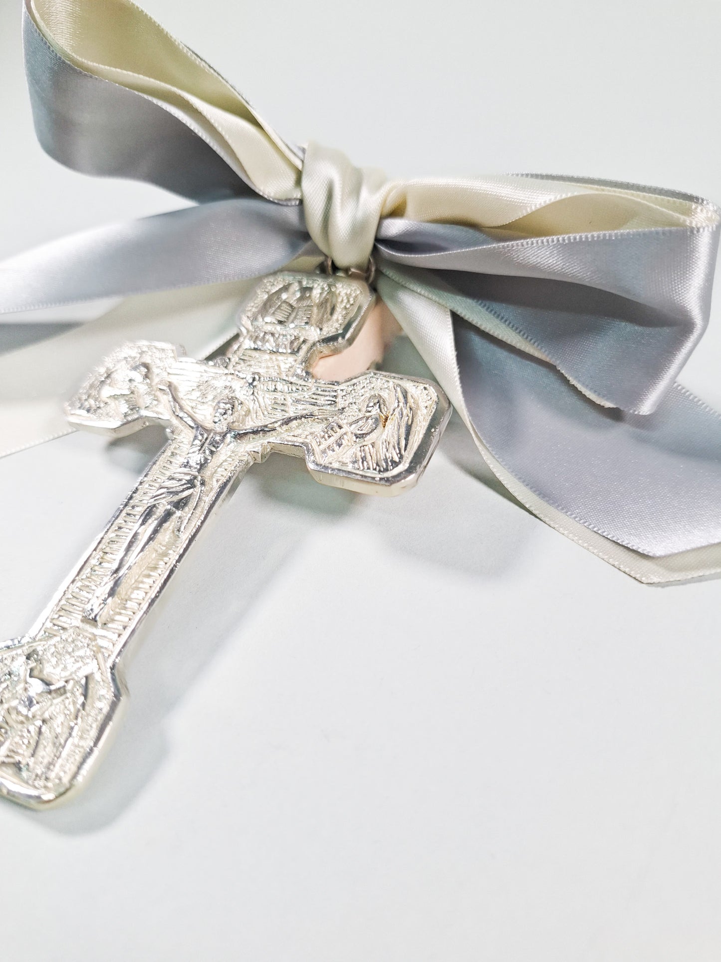 Cruz plateada con moño gris