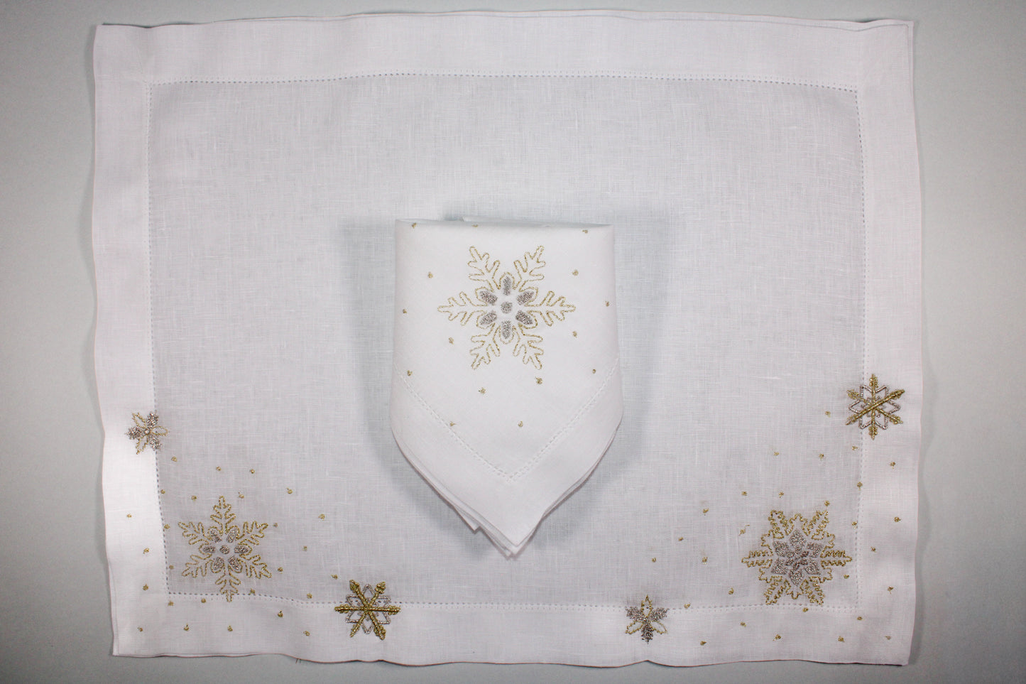 JGO DE 4 INDIVIDUALES Y 4 SERVILLETAS PREMIUM COPOS DE NIEVE PLATEADOS.